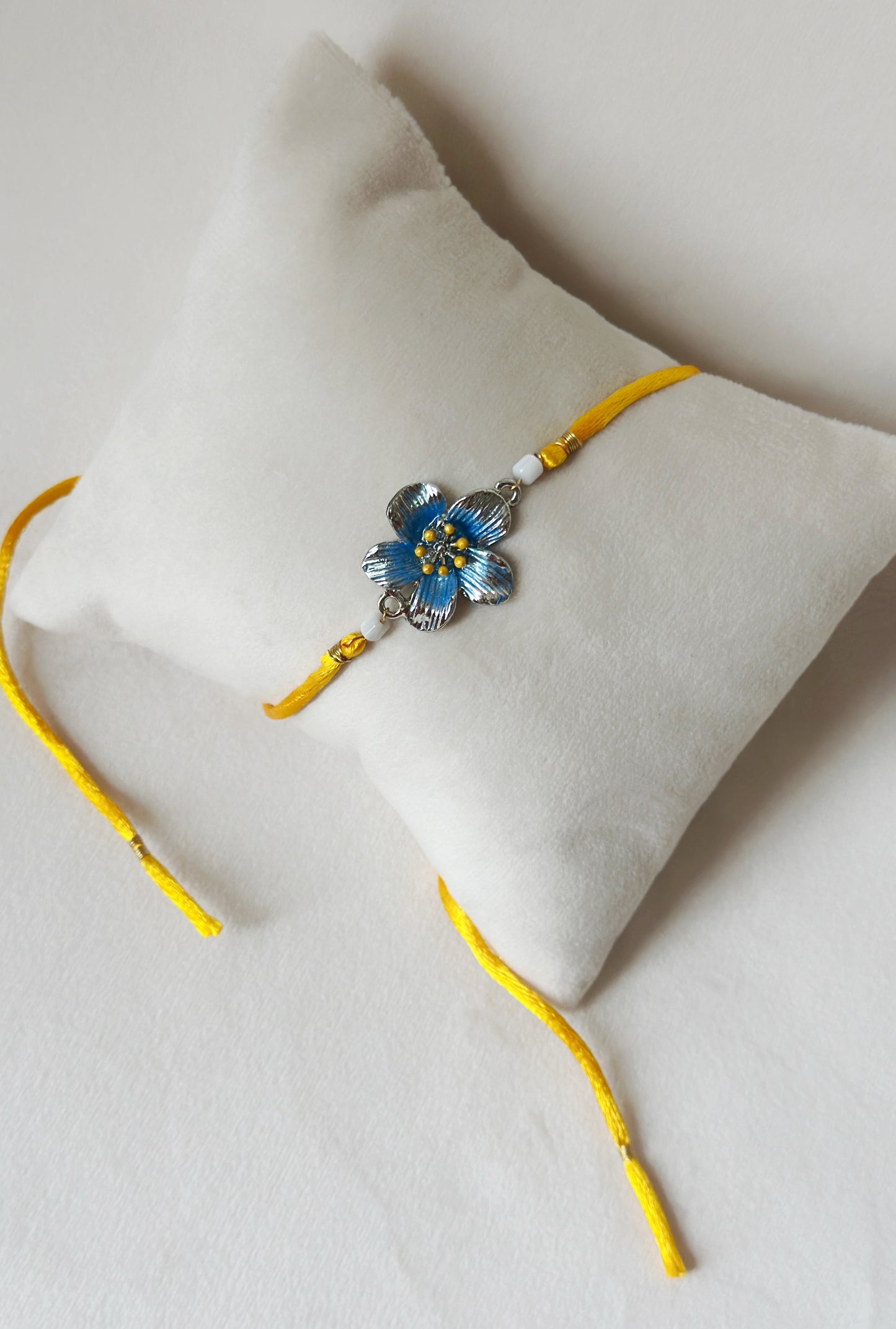 Floral Rakhi Small Silver and saffron