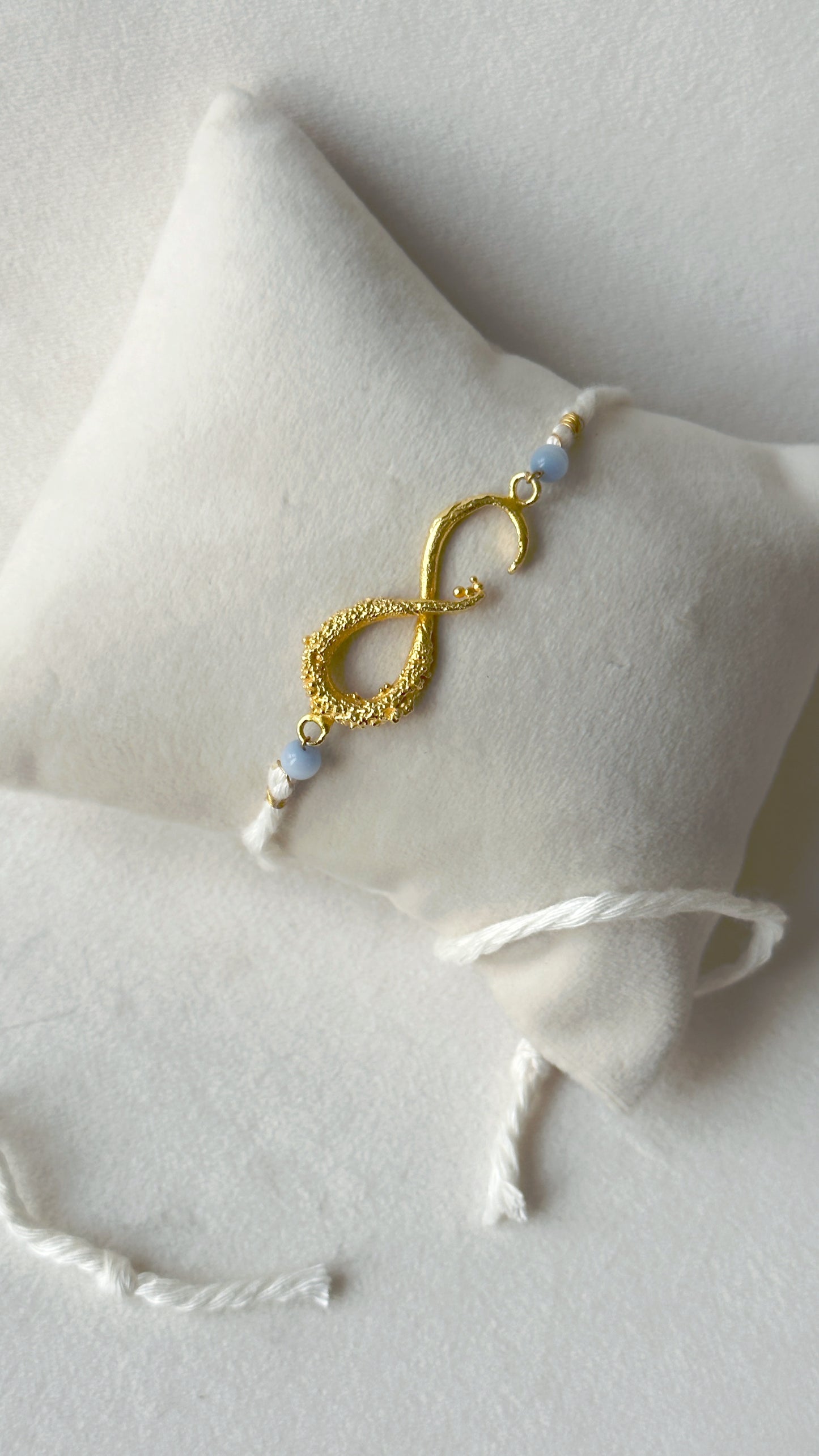 Infinity Rakhi Gold and White