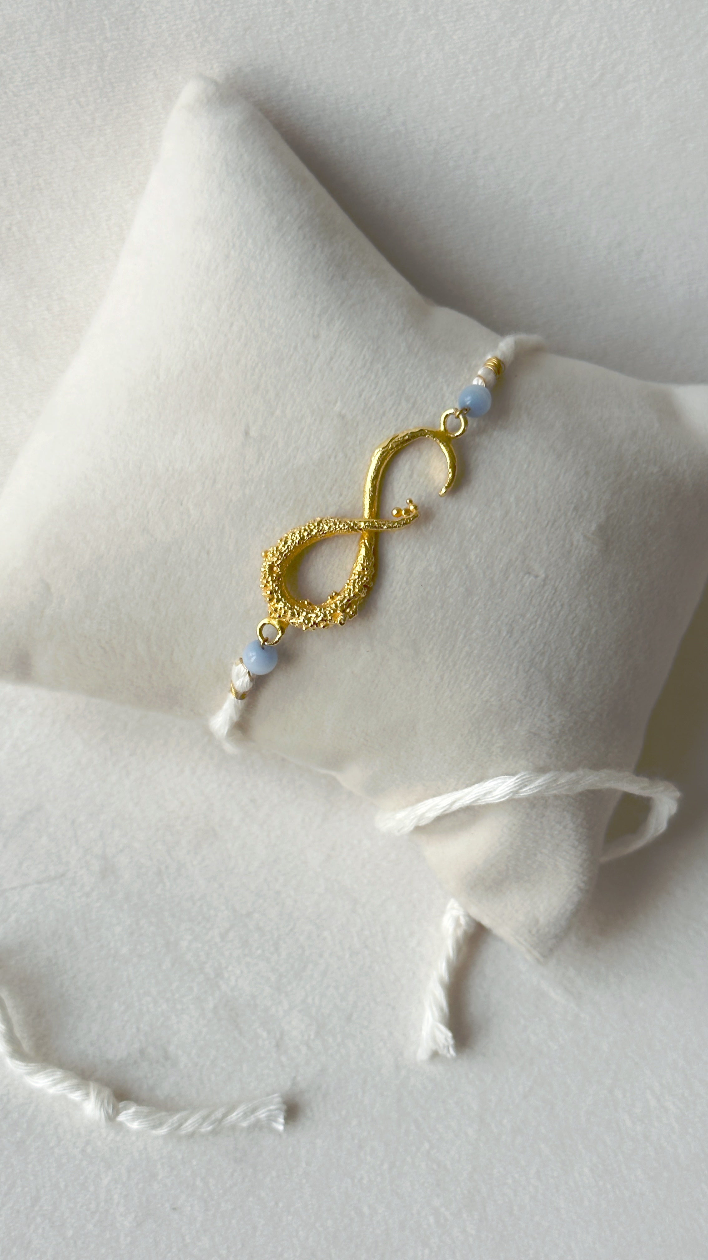 Infinity Rakhi Gold and White
