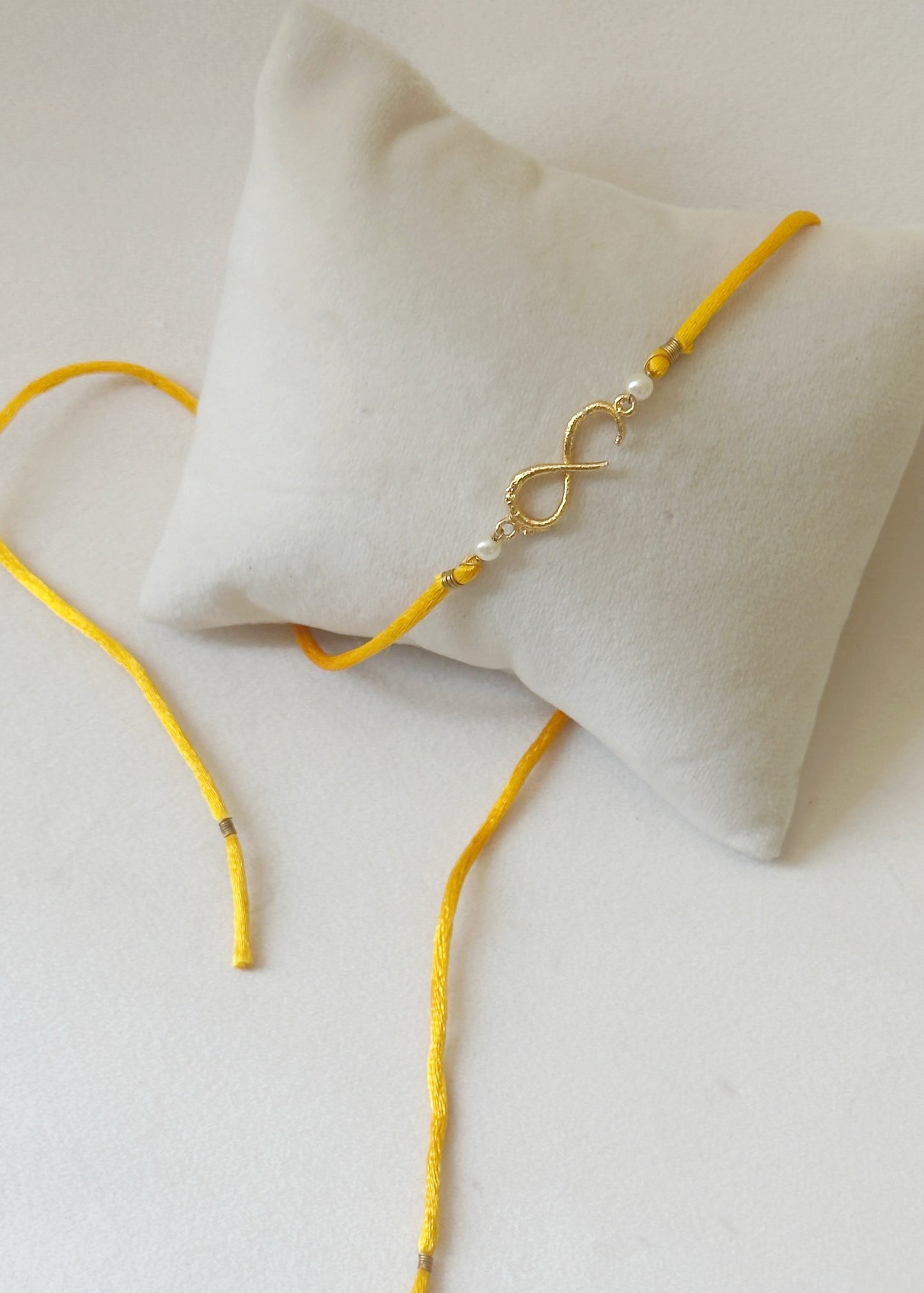Small Infinity Rakhi Gold and Saffron with Pearls